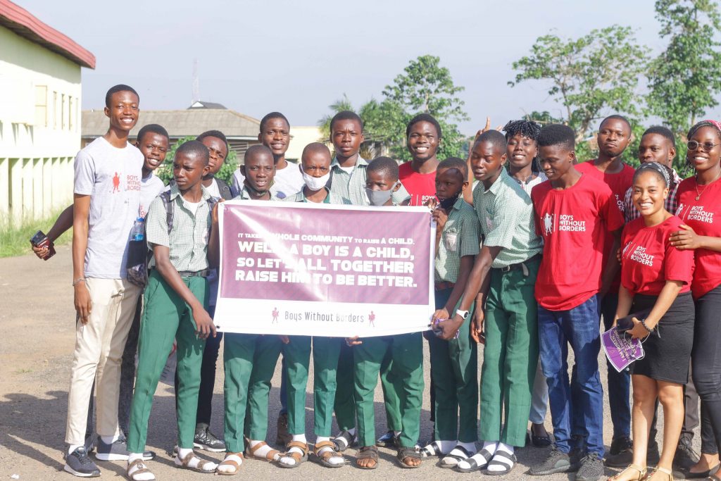 Secondary school boys carrying a banner asking what boy child advocacy is.